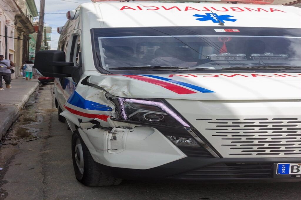 Ambulancia con daños significativos en la parte delantera derecha.