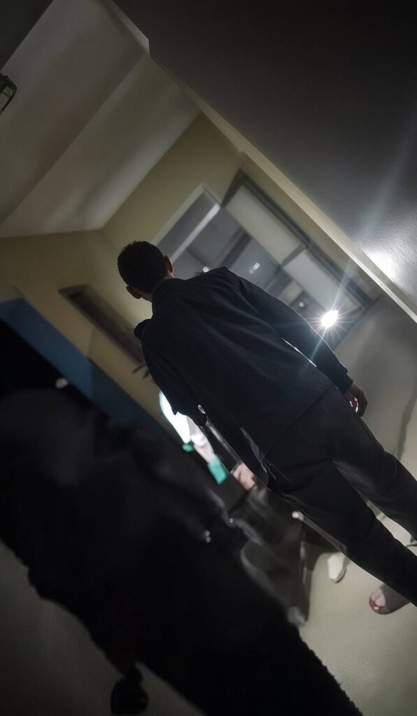 Hombre de espaldas en interior minimalista con iluminación dramática.