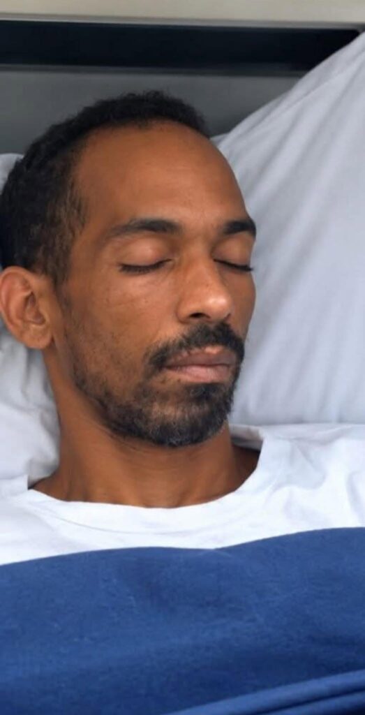 Hombre con barba descansando con los ojos cerrados en cama.