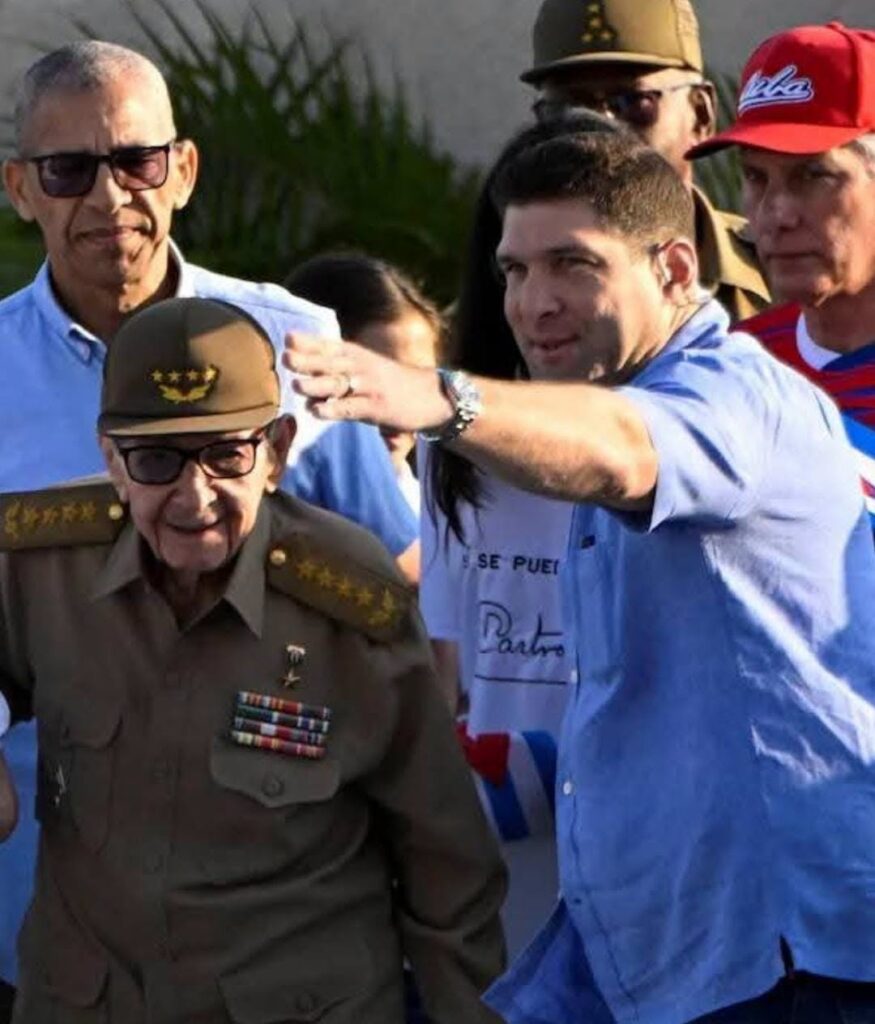 Raúl Castro con uniforme militar y acompañante señalando el camino.