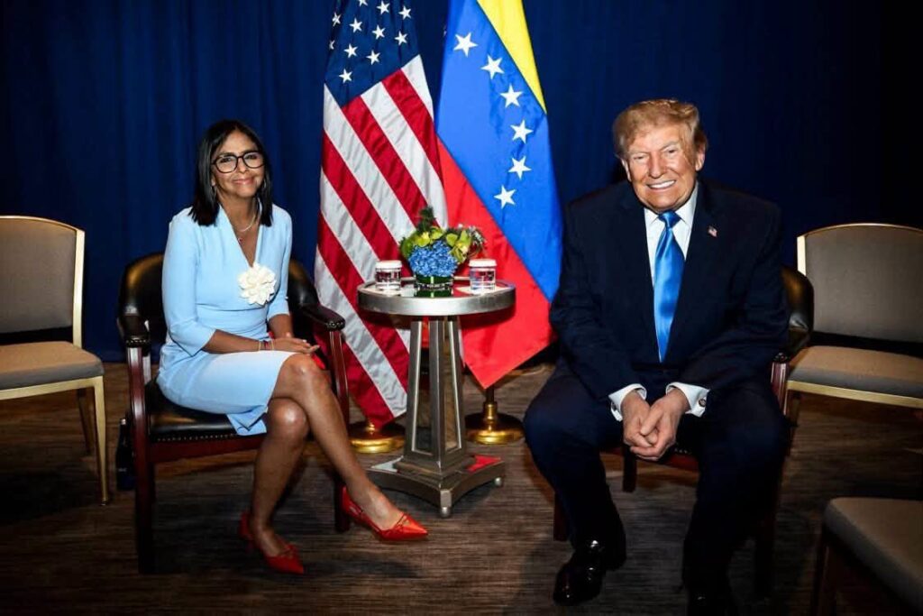 Donald Trump y Delcy Rodríguez sentados ante banderas nacionales.