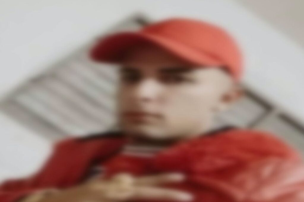 Hombre joven con gorra y chaqueta de color rojo.