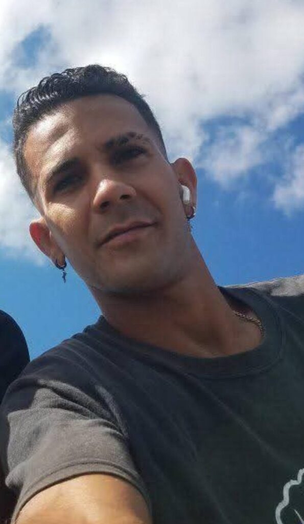 Primer plano de un hombre joven bajo el cielo azul.