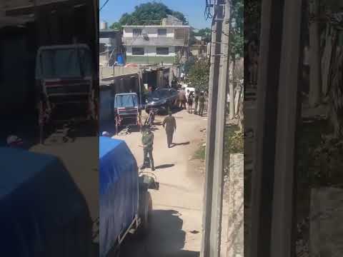Escena callejera con presencia policial y vehículos en barrio urbano.