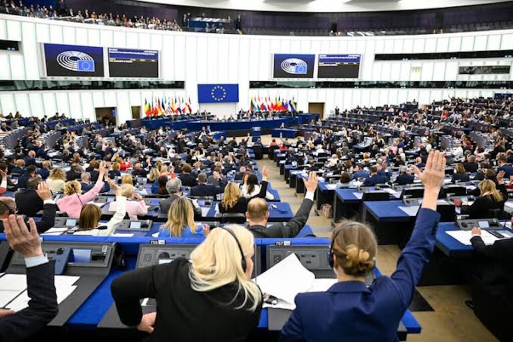 Eurodiputados votando a mano alzada en el Parlamento Europeo.