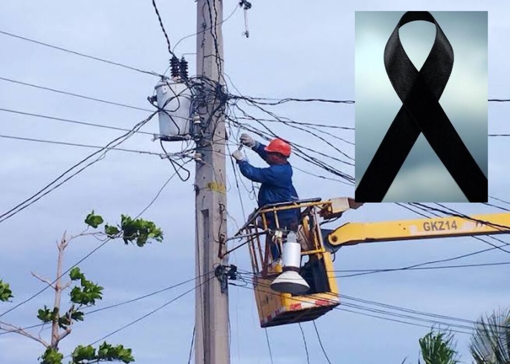 Electricista trabajando en poste eléctrico con lazo negro de luto.