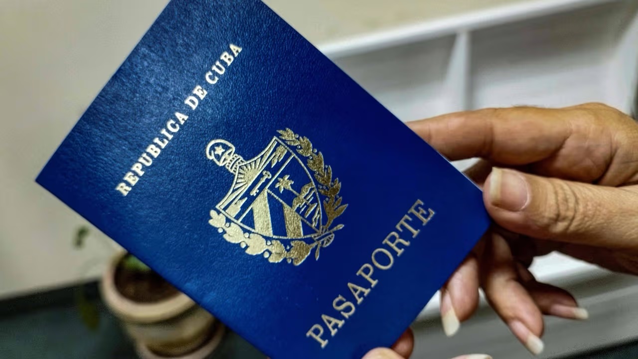 Primer plano de una mano sujetando un pasaporte cubano.