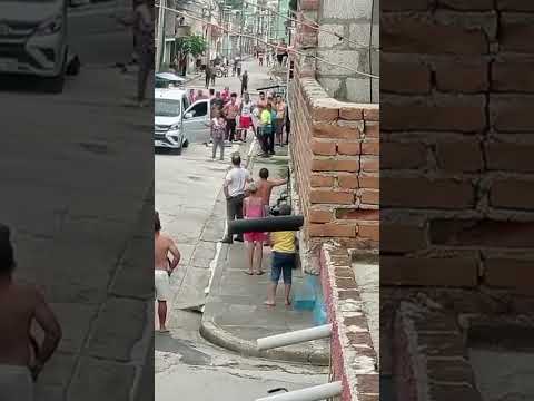 Grupo de personas reunidas en una calle residencial concurrida.